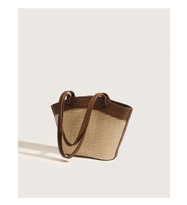 Close-up of woven straw texture and premium brown leather handle on a vintage bag