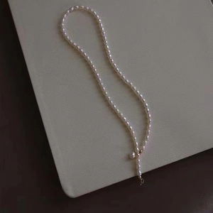 Elegant baroque freshwater pearl necklace with gold clasp on minimalist beige background