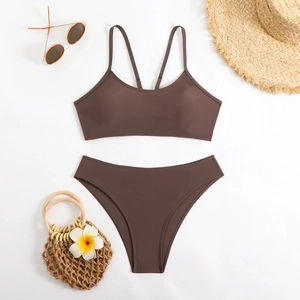 Flat lay of brown two-piece bikini set with straw hat and sunglasses for summer vacation
