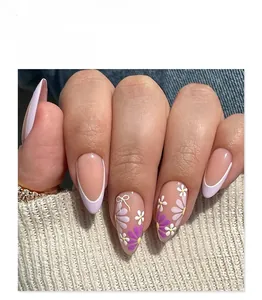Detail of almond-shaped lavender press-on nails with 3D bows and floral patterns