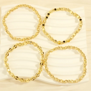 Detailed view of four elastic gold beaded bracelets with frosted and textured beads