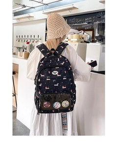 Detail of cute black cartoon dog backpack with clear front pocket for badges and pins