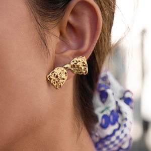 Boucles d'oreilles nœud creux en acier inoxydable doré 18K sur l'oreille du modèle