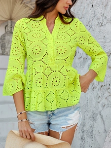 Détail du chemisier en dentelle vert fluo avec broderie évidée et ourlet à basque