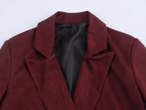 Detail of burgundy faux suede jacket showing structured notched lapels and fine texture