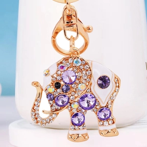 Detail of a golden elephant keychain with purple crystals, rhinestones, and lobster clasp