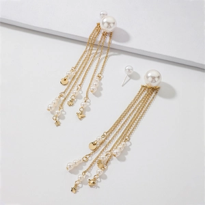 Detail of gold fringe earrings featuring pearls, stars, and four-leaf clover pendants