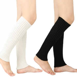 Close-up of black and white knitted leg warmers showing soft texture and ribbed cuffs