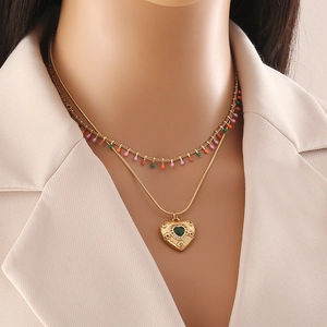 Collier double rang doré avec perles colorées et pendentif cœur serti d'une pierre verte