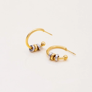 Close-up of modern two-tone gold and silver stainless steel C-shaped earrings