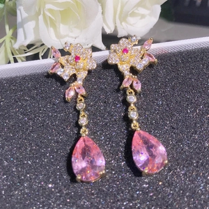 Detail of pink floral earrings with pear-shaped teardrop gems and long tassels