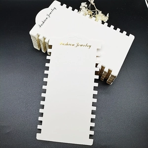 White rectangular paper jewelry display cards with 12 slots for necklaces and hair ties