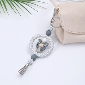 Detail of silicone car pendant with leopard print ring, gray tassel and cow head charm