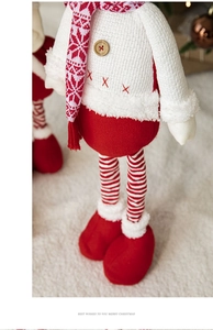 Close-up of telescopic Christmas plush doll showing red knit fabric and button detail