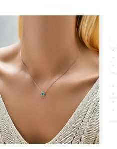 Close-up of s925 silver necklace with a round Paraiba blue stone pendant on model