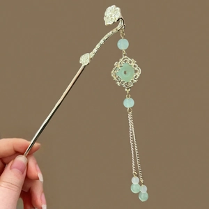 Épingle à cheveux dorée avec anneau en imitation jade et longs pompons délicats