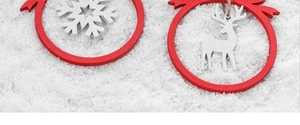 Detail of red and white wooden Christmas ornaments with snowflake and reindeer patterns