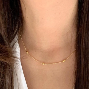 Elegante goldene doppellagige Halskette mit ovalen Perlen auf einer zarten Kugel-Kette