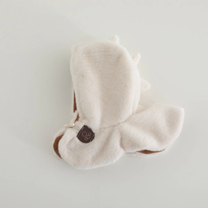 Dettaglio del cappello invernale in peluche con stampa di zampa e chiusura a bottone