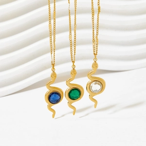 Golden snake jewelry set with blue green and clear crystals on white background