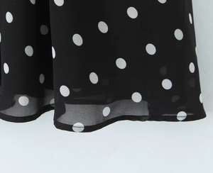 Makrodetail feiner Saumnähte an einem schwarz-weiß gepunkteten Chiffonkleid