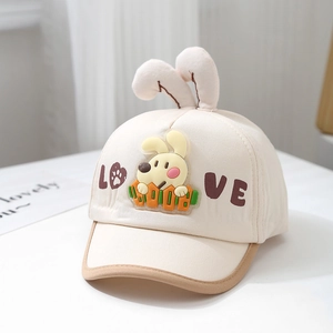 Close-up of baby baseball cap with plush bunny ears and LOVE lettering on cream fabric