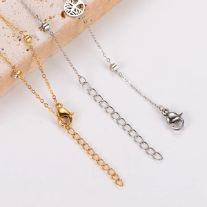 Detailed close-up of tree of life anklet lobster clasps in gold and silver finish