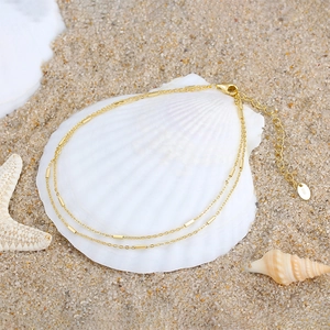 S925 sterling silver double layer anklet in gold finish with starfish on beach sand