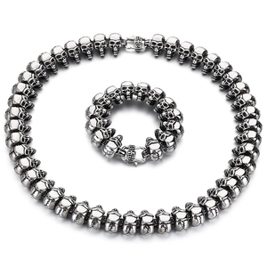 Punk skull necklace and bracelet set in polished silver steel on white background