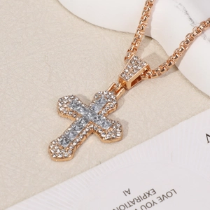 Macro shot of gold cross pendant with cubic zirconia stones on a classic box chain