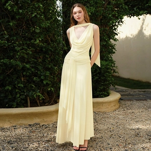 Detail of light yellow backless maxi dress featuring pleated chiffon fabric and halter neck