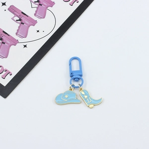 Detail of blue cowboy hat and boot charms on key ring with star accents and gold trim