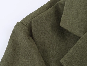 Vue détaillée de la texture du tissu vert et de la structure du col d'un blazer élégant