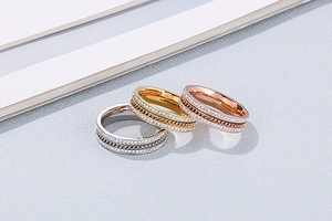 Close-up of triple-layer titanium steel rings with crystal paving and Cuban chain design