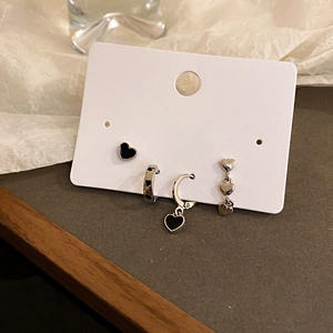 Close-up of six-piece heart-shaped silver stud earring set on a white display card