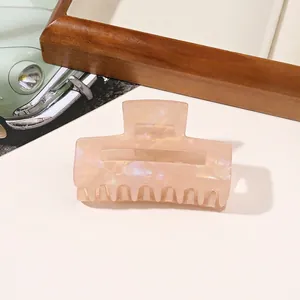 Macro shot of a large square marble texture hair claw clip in soft nude pink finish