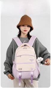 Detail of light purple and beige backpack with cloud charm shown on model
