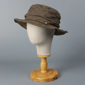 Brown vintage distressed linen bucket hat with metal detail on head model