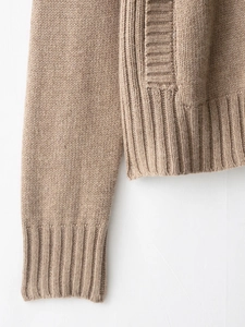 Close-up of camel knit cardigan showing thick ribbed cuffs and textured knit details