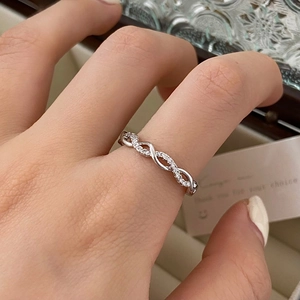 Minimalist twisted zircon ring in silver finish with pavé set crystals on a female hand