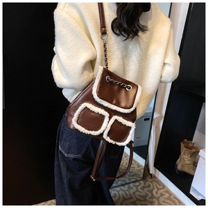 Detail of vintage brown leather backpack with plush faux fur trim and chain straps