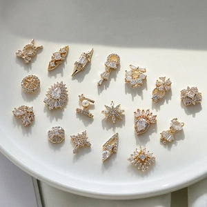 Macro di ciondoli per unghie geometrici placcati in oro con zirconi scintillanti su piatto