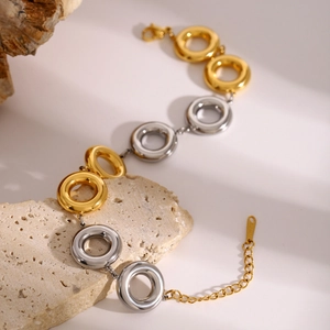 Detail of mixed-metal gold and silver thick link bracelet with lobster clasp on stone