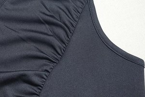 Detail view of high-elastic black fabric with delicate ruffled edges and precise stitching