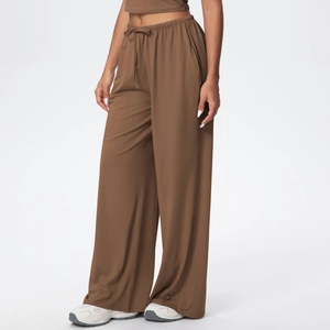 Detail of loose dark brown wide-leg trousers with drawstring elastic waistband