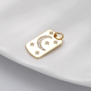Macro detail of gold rectangular moon and star pendant with sparkling cubic zirconia