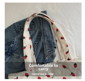 Close-up of strawberry corduroy tote bag handle with thick textured fabric and soft print