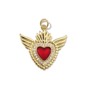 Detail view of gold-plated winged heart pendant with red enamel and zircon accents