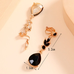 Detail view of gold clip earrings with black stones measuring 5.2cm by 1.3cm in length