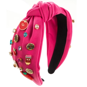 Pink knotted headband with apple and pencil patterns plus sparkling crystals